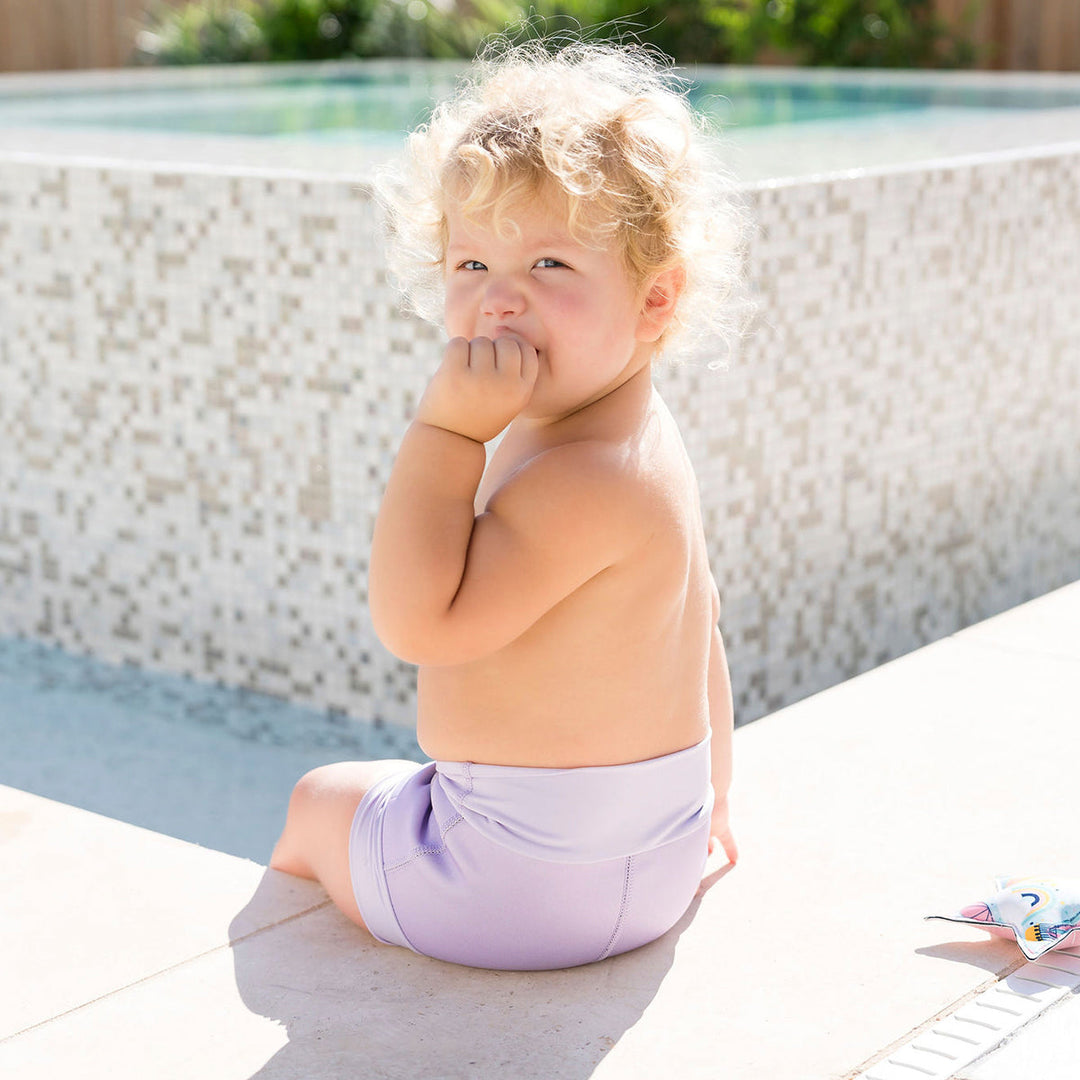 Baby wearing lilac colour swim nappy back angle