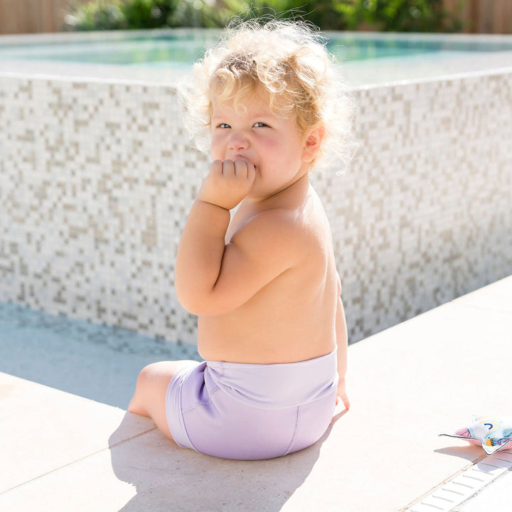 Baby wearing lilac colour swim nappy back angle