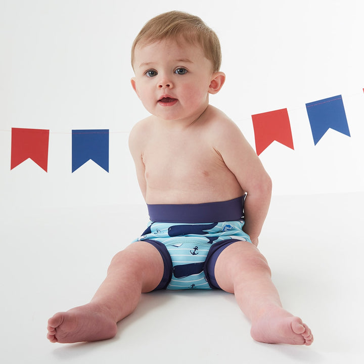 Baby wearing a swim diaper in blue vintage whale print