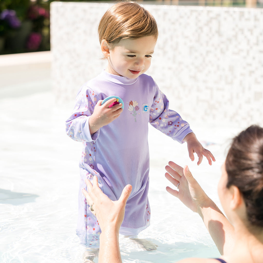 Baby wearing a warm baby westsuit in floral print
